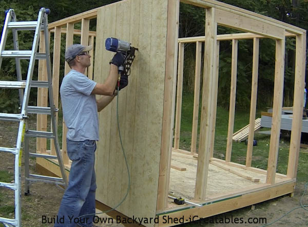 Nailing on the first siding piece on the shed wall